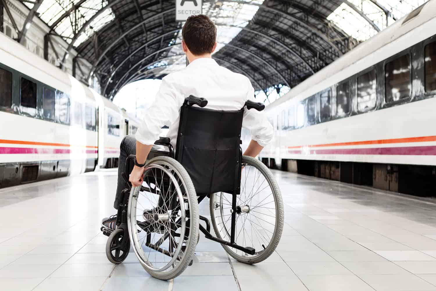 person in a wheelchair waiting for the train at the rail station