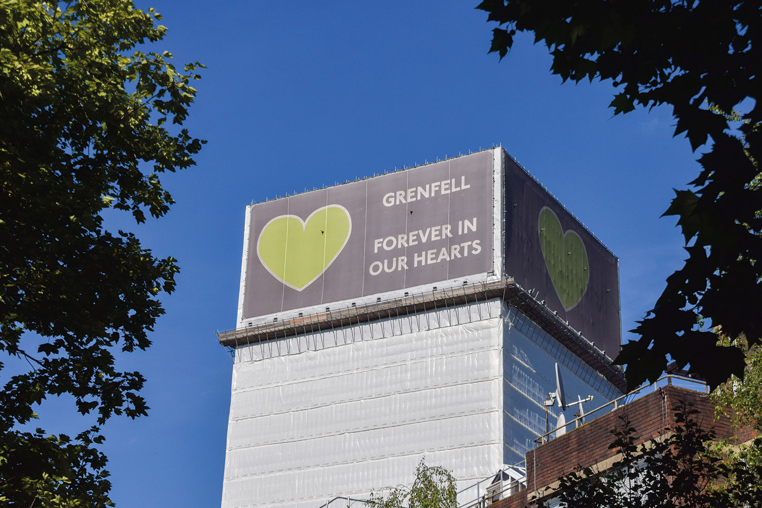 photo of Grenfell Tower with green heart and ‘Forever in our hearts’ cover over the top of the building