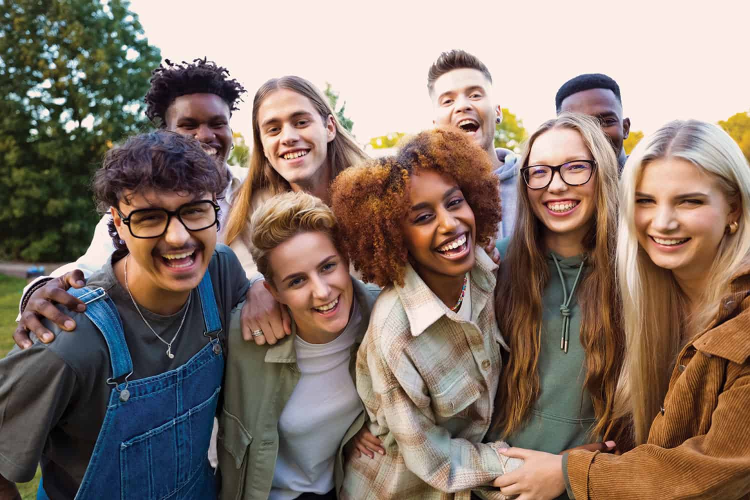 Diverse group of young people laughing and smiling at the camera.