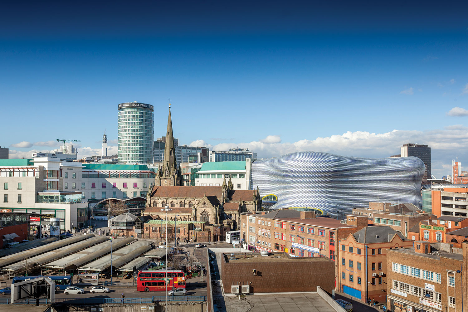 photo from high vantage point of Birmingham city centre, centred around the curving, silvery Selfridges Building, part of the Bullring Shopping Centre