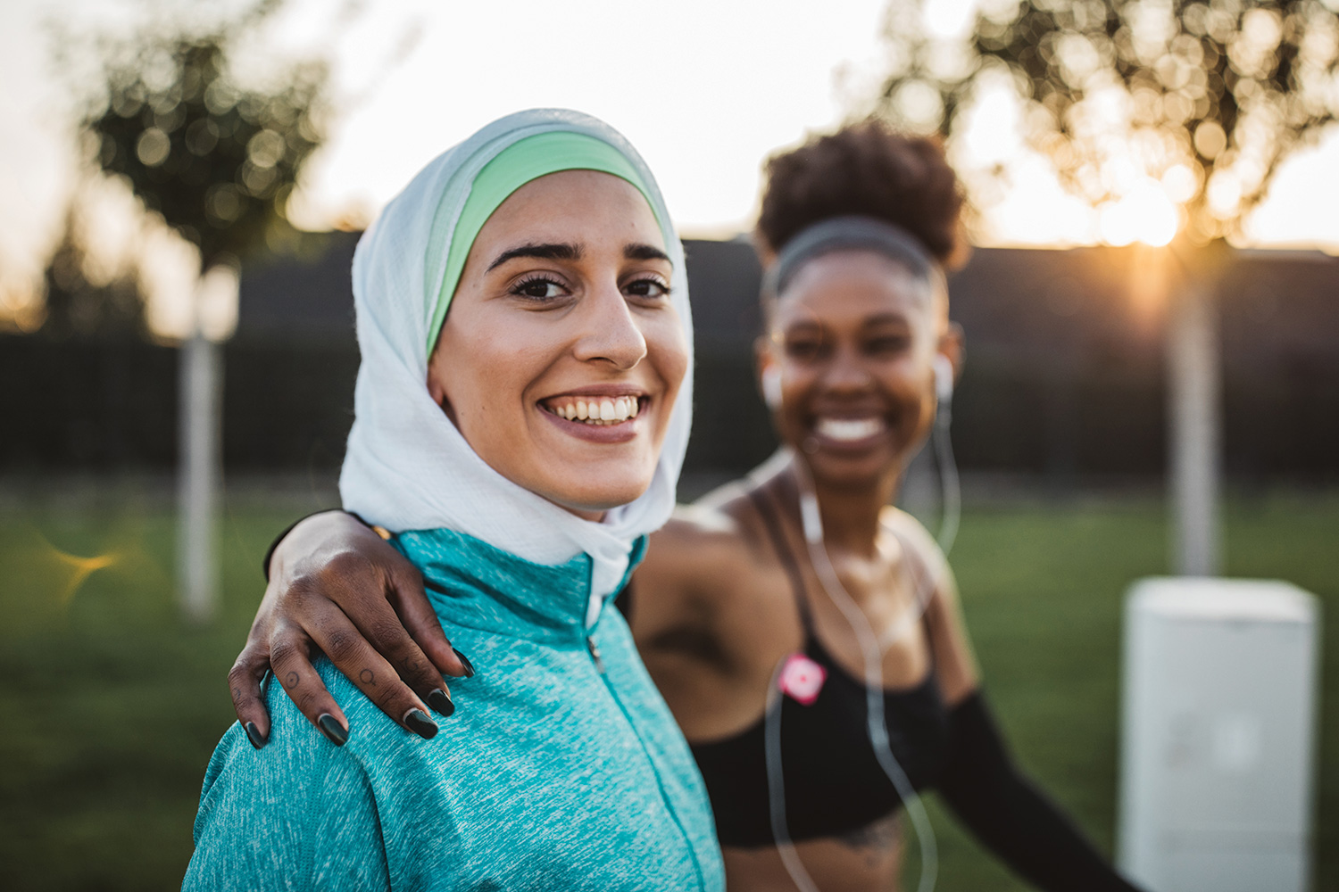 Close-up of two young women exercising in park.