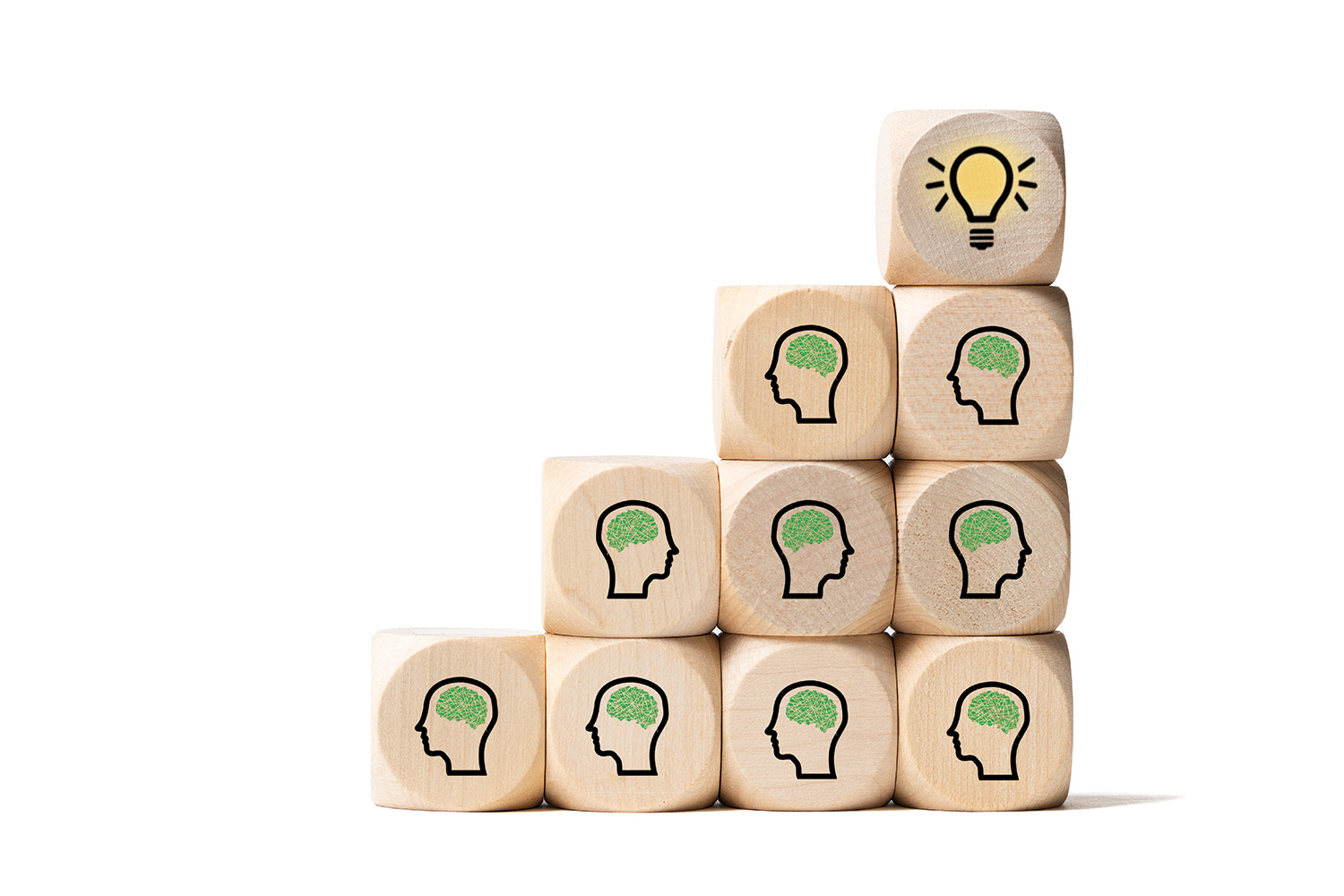 photos of wooden dice decorated with outlines of heads showing brains as ‘grey matter’, and with lightbulbs on them, being stacked by a human hand