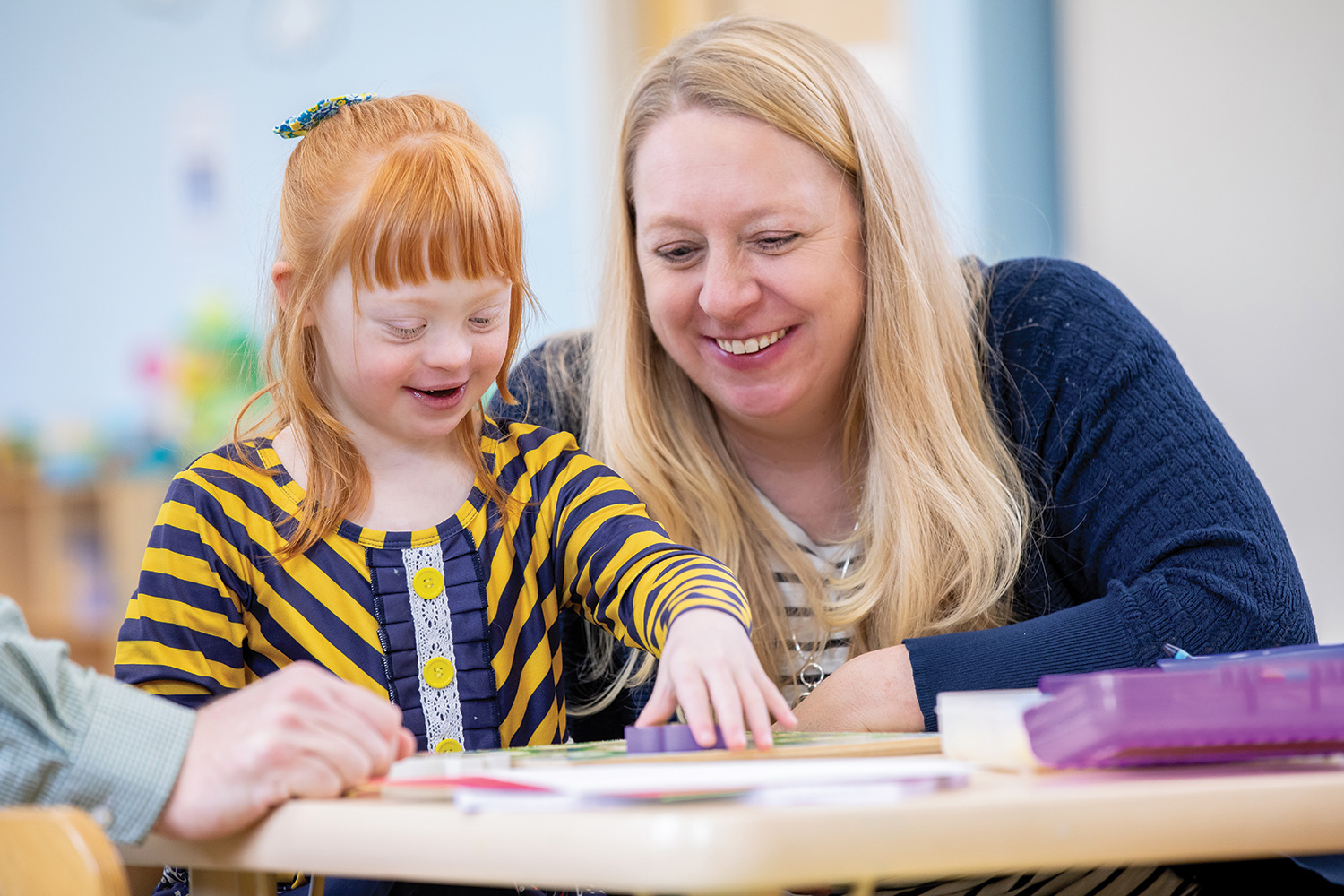 A carer teaching a girl with down's syndrome