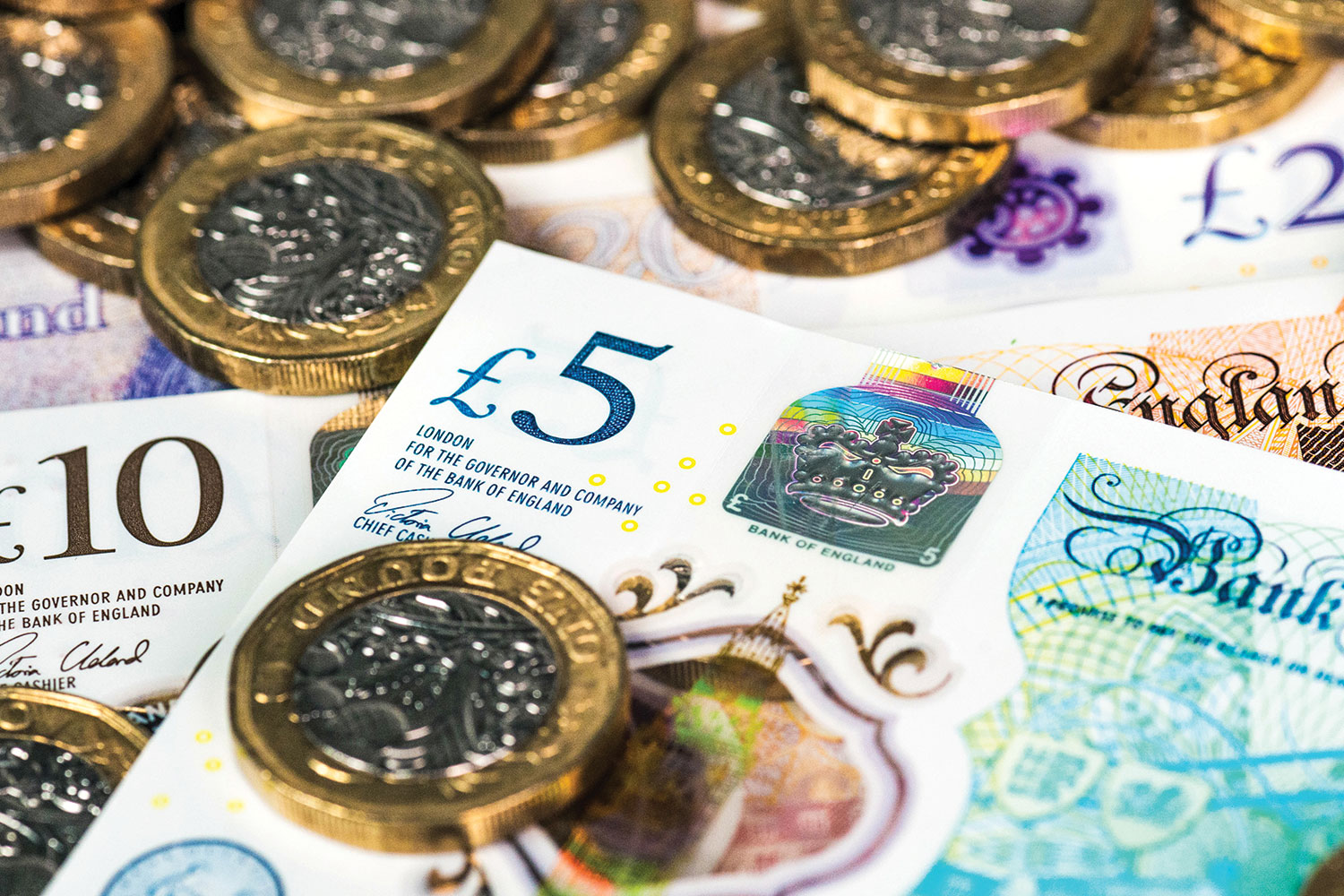 Close-up of UK bank notes and pound coins.