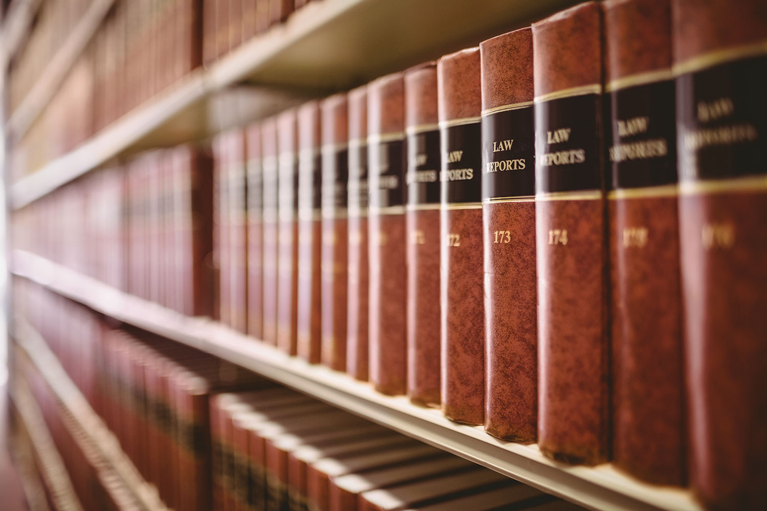 close up of rows of red law report books on a book shelf